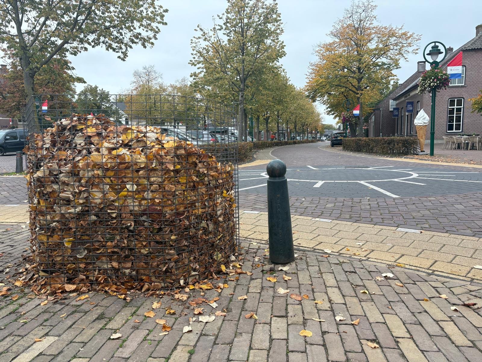 een straat met een bladbak met bladeren