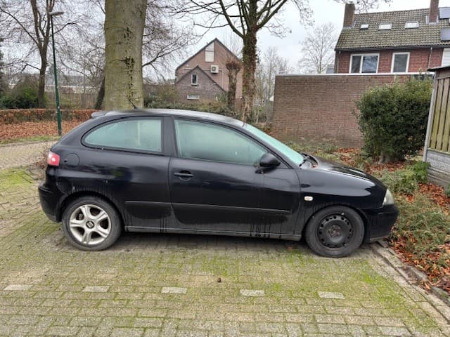 een zwarte auto met lekke band